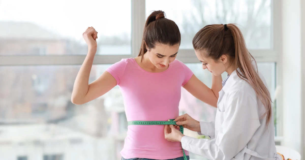 A healthcare professional measuring a woman’s waist during a medical weight loss in Tallahassee, FLA